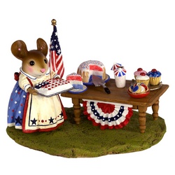 Mother mouse standing in front of a garden table with RWB cakes and flags