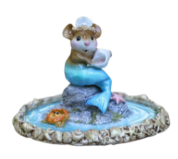 Mermouse sits on a rock inside a tide pool