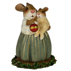 Mum shows her new baby the shiny Christmas ornament. 