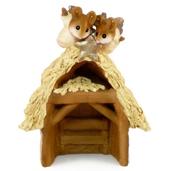 Wooden stable with thatched roof and two mouse angels on top