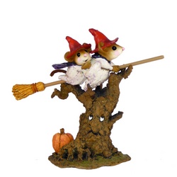 Two moce whitches fly their browm stick over an animate with a pumpkin at the base
