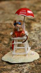 Whimsical beach mouse lifeguard sits proudly atop a classic white lifeguard chair