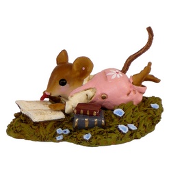 Young mouse lying in the grass reading a book