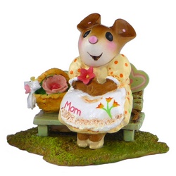 Mother mouse holding a flower and  sitting on a wood banch with a basket of flowers