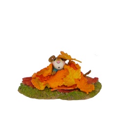 Young mouse covered in fall leaves