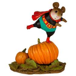 Boy mouse superhero standing on a large pumpkin