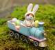 Here comes a mouse, dressed as the Easter bunny driving the Easter train, carrying pastel colored Easter eggs 
