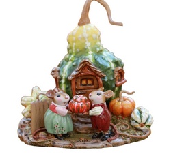 This mouse couple is ready to share their good yield, standing in front of their house holding a pumpkin