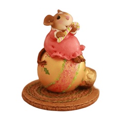 Young mouse with candy cane perched on a Christams ornament
